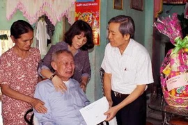 Thăm và tặng quà các gia đình chính sách nhân ngày thương binh, liệt sỹ. (Ảnh: Thanh Long/TTXVN)