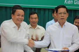 Tổng Giám đốc TTXVN (trái) và Chủ tịch UBND tỉnh Kiên Giang trao đổi Văn bản thỏa thuận tại lễ ký. (Ảnh: Lê Sen/TTXVN)