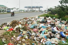 Rác thải đổ ra quốc lộ. (Ảnh: Ngô Lịch/TTXVN). 