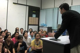 Đại diện Ban quản lý lao động tiếp xúc công nhân tại trại tạm giữ của Cục Di trú Penang. (Ảnh: Xuân Triển/Vietnam+)