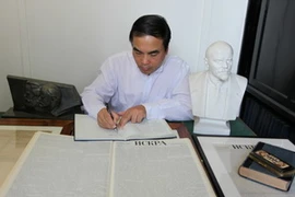 PGS.TS Vũ Văn Phúc ghi cảm tưởng trong căn phòng mà Lenin từng làm việc tại Thư viện tưởng nhớ Marx. (Ảnh: Lê Phương/Vietnam+)