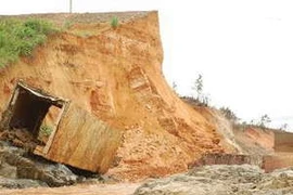 Nước lũ cuốn trôi cả khối bêtông nằm trong thân đập. (Nguồn: TTXVN)