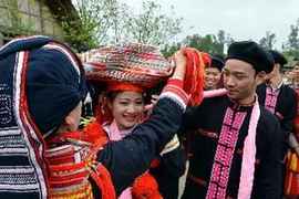 Mẹ chú rể bỏ khăn che mặt cho cô dâu trong đám cưới của người Dao. (Ảnh minh họa: Thanh Hà/TTXVN)