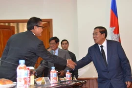 Thủ tướng Hun Sen bắt tay thủ lĩnh đối lập Sam Rainsy trước khi bắt đầu cuộc họp. (Ảnh: Trần Chí Hùng/Vietnam+)