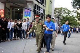 Thanh niên tình nguyện tham gia phục vụ Lễ viếng Đại tướng Võ Nguyên Giáp tại Hà Nội. (Ảnh: TTXVN)