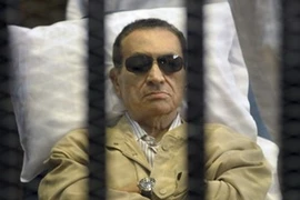 Cựu Tổng thống Ai Cập Hosni Mubarak nằm trong một buồng có chấn song trong phiên xét xử tại thành phố Cairo. (Nguồn: AP)