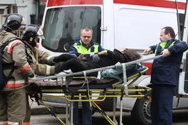 Chuyển một phụ nữ bị thương đi cấp cứu. (Ảnh: AFP/TTXVN). 