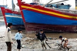 Trẻ em nhặt phế thải trên bãi biển. (Ảnh minh họa: Dương Ngọc/TTXVN)