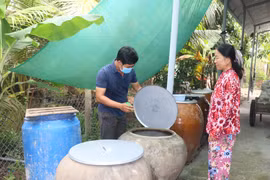 Nhân viên y tế giám sát mật độ lăng quăng, muỗi và tuyên truyền các biện pháp phòng, chống sốt xuất huyết cho hộ dân tại tỉnh Vĩnh Long. (Ảnh: Lê Thúy Hằng/TTXVN)