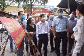 Thứ trưởng Bộ Y tế Nguyễn Trường Sơn thăm hỏi cán bộ địa phương trong công tác chống dịch. (Ảnh: Đinh Hằng/TTXVN)