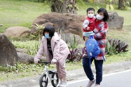 Người dân thực hiện nghiêm túc việc đeo khẩu trang khi ra khỏi nhà để phòng chống dịch COVID-19. (Ảnh: Phạm Kiên/TTXVN)