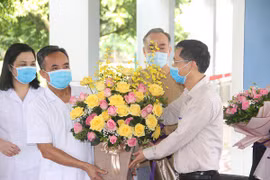 Một bệnh nhân được công bố khỏi bệnh tặng hoa cho các y bác sỹ. (Ảnh minh họa: Vietnam+)