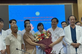 Gia đình Hà Thị B. tặng hoa cảm ơn các y bác sỹ Bệnh viện Bạch Mai. (Ảnh: PV/Vietnam+)