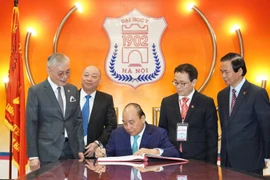 Thủ tướng Nguyễn Xuân Phúc đến dự Lễ kỷ niệm 65 năm Ngày Thầy thuốc Việt Nam tại Trường Đại học Y Hà Nội và viết vào sổ lưu niệm. (Ảnh: PV/Vietnam+)