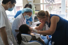 Các chuyên gia của Chương trình thăm khám cho các bệnh nhân. (Ảnh: PV/Vietnam+)