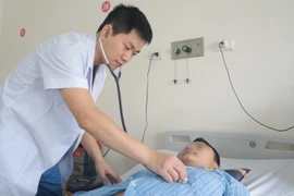 Bác sỹ kiểm tra, theo dõi sức khỏe cho bệnh nhân. (Ảnh: PV/Vietnam+)