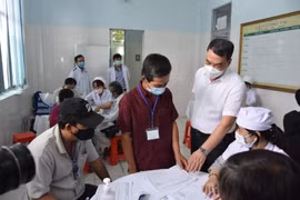 Lãnh đạo Bộ Y tế kiểm tra thủ tục trước khi tiến hành tiêm thử nghiệm. (Ảnh: PV/Vietnam+)