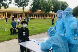 Tiếp nhận 198 công dân Việt Nam trở về từ Mỹ cách ly tập trung. (Ảnh: Hoa Mai/TTXVN) 