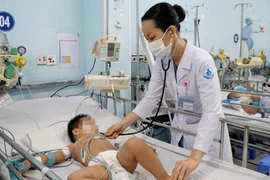 Bác sỹ Bệnh viện Nhi đồng 1 Thành phố Hồ Chí Minh thăm khám cho trẻ mắc bệnh tay chân miệng. (Ảnh: TTXVN phát)