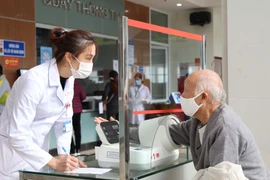 Người dân đi khám chữa bệnh bảo hiểm y tế. (Ảnh: Quang Duy/TTXVN)