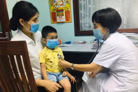 Bác sỹ khám cho bệnh nhi. (Ảnh: PV/Vietnam+)