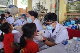 Bác sĩ Bệnh viện Hữu nghị Việt Nam-Cu Ba khám răng miệng cho học sinh trong chương trình. (Ảnh: PV/Vietnam+)