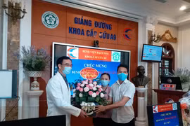 Nữ bệnh nhân và người thân tặng hoa cảm ơn các y bác sỹ đã cứu sống. (Ảnh: PV/Vietnam+)