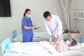 Bác sỹ thăm khám cho bệnh nhân sau phẫu thuật. (Ảnh: PV/Vietnam+)