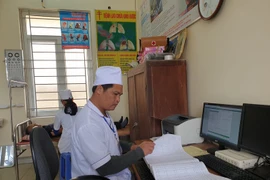 Bác sỹ theo dõi sổ khám bệnh tại một trạm y tế xã ở tỉnh Ninh Bình. (Ảnh: T.G/Vietnam+)