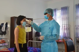 Điều dưỡng tại Khu cách ly tập trung của tỉnh Bà Rịa-Vũng Tàu kiểm tra thân nhiệt của người cách ly tập trung. (Ảnh: Hoàng Nhị/TTXVN)