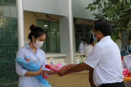 Trao quà và trao giấy xuất viện cho trường hợp mắc COVID-19 sau thời gian điều trị, tại Bệnh viện Đa khoa Sa Đéc, Đồng Tháp. (Ảnh: Chương Đài/TTXVN)