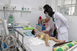 Điều trị cho trẻ mắc bệnh tay chân miệng. (Ảnh: Huỳnh Phúc Hậu/TTXVN)