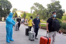 Nhân viên y tế hướng dẫn chuyên gia, lao động nước ngoài đi đường riêng khi vào khách sạn cách ly. (Ảnh: Đồng Thúy/TTXVN)