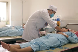 Bác sỹ tại Bệnh viện đa khoa tỉnh Phú Yên thăm khám cho bệnh nhân sốt xuất huyết. (Ảnh: Xuân Triệu/TTXVN)