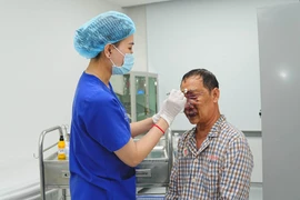 Nhân viên y tế chăm sóc cho bệnh nhân sau phẫu thuật. (Ảnh: PV/Vietnam+)