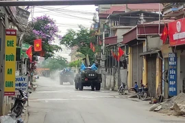 Lực lượng chức năng Bộ Tư lệnh Thủ đô Hà Nội sử dụng xe chuyên dụng phun thuốc khử khuẩn tại huyện Thường Tín. (Ảnh: TTXVN phát)