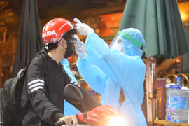 Nhân viên y tế kiểm tra và sát khuẩn cho những người vào bênh viện. (Ảnh: Dương Giang/TTXVN)
