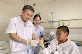 Bác sỹ kiểm tra ngón tay của bệnh nhân sau khi phẫu thuật. (Ảnh: PV/Vietnam+)