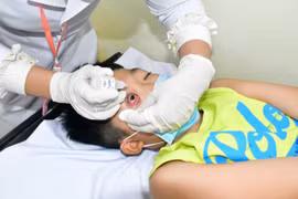 Bác sỹ khám cho một bệnh nhi bị đau mắt đỏ. (Ảnh: TTXVN phát)
