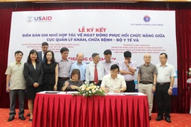 Lễ ký kết Biên bản ghi nhớ với các tổ chức phi chính phủ quốc tế và trong nước về hoạt động phục hồi chức năng. (Ảnh: PV/Vietnam+)