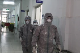 Các bác sỹ Bệnh viện Chợ rẫy Thành phố Hồ Chí Minh mặc đồ bảo hộ trước khi vào khu vực cách ly. (Ảnh: Đinh Hằng/TTXVN)