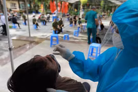 Nhân viên y tế lấy mẫu xét nghiệm cho người dân tại Hà Nội. (Ảnh: TTXVN/Vietnam+)