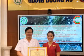 Phó giáo sư Đào Xuân Cơ trao giấy khen cho nữ điều dưỡng Đặng Thị Hạ. (Ảnh: PV/Vietnam+)