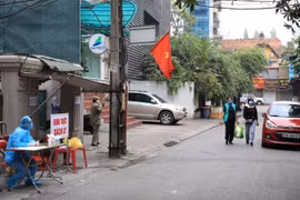 Lực lượng chức năng tiến hành phong toả nơi ở của một bệnh nhân mắc COVID-19. (Ảnh: Minh Đức/TTXVN)
