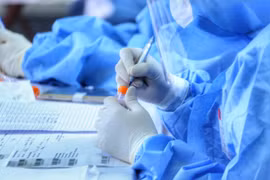 Nhân viên y tế làm công tác lấy mẫu, xét nghiệm. (Ảnh: TTXVN/Vietnam+)