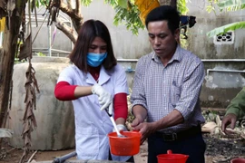 Lực lượng Y tế khử khuẩn giếng khơi cho người dân. (Ảnh: Công Tường/TTXVN)