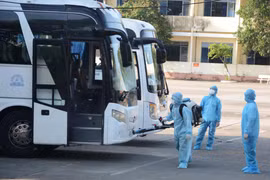 Nhân viên y tế phun thuốc khử trùng vào xe chở công dân từ Hàn Quốc trở về. (Ảnh: Văn Dũng/TTXVN)
