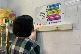 Người dân đọc thông tin tuyên truyền về phòng chống HIV/AIDS. (Ảnh: T.G/Vietnam+)