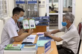 Nhân viên y tế tư vấn khám chữa bệnh cho người dân. (Ảnh: PV/Vietnam+)