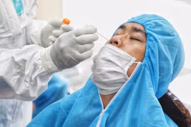 Nhân viên y tế lấy mẫu xét nghiệm COVID-19 cho người dân. (Ảnh: Thành Đạt/TTXVN)